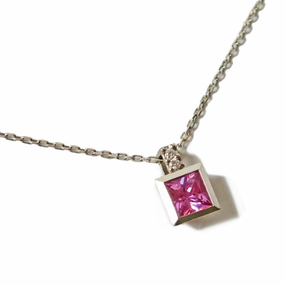 Princess cut pink sapphire set in a platinum bezel on a 1 mm chain 