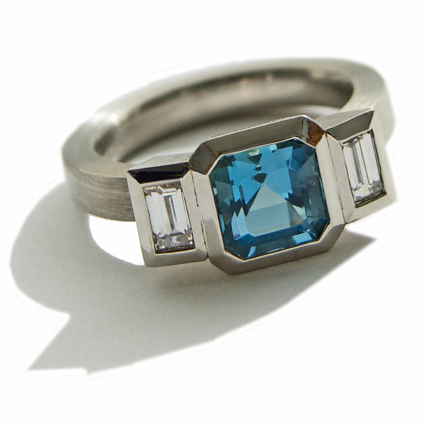 3 stone bezel set ring with aquamarine and diamonds in platinum.