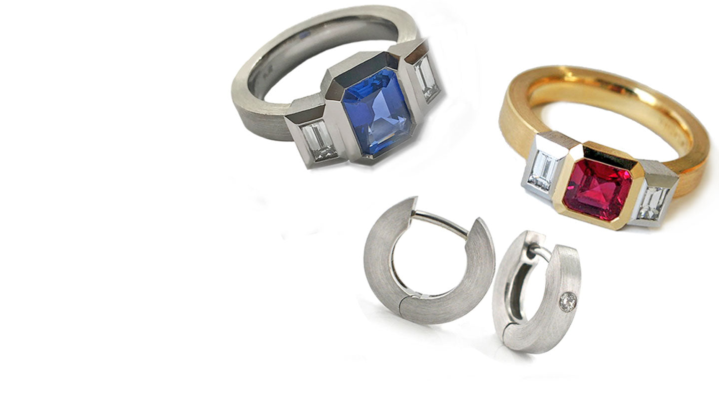 Two 3 stone bezel set rings with gemstones and two platinum hoop earrings on a white background