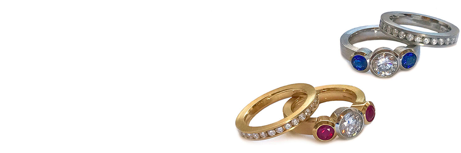 Two bezel set round 3 stone rings with matching anniversary bands.