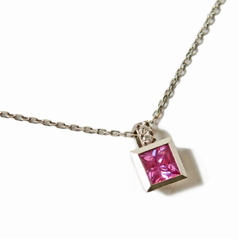 Princess cut pink sapphire set in a platinum bezel on a 1 mm chain 