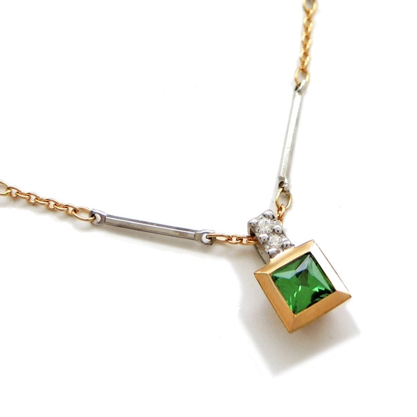 Princess cut tsavorite in an 18k gold bezel with 2 small diamonds in the bail and a bar / link chain