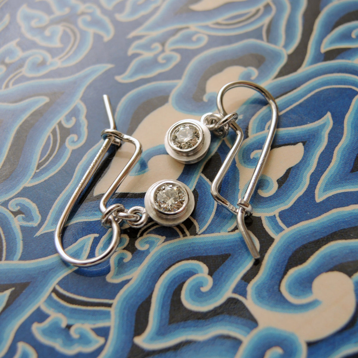 Handmade earring 18KPW wires that hook to close with .30 tcw. diamonds in bezels 