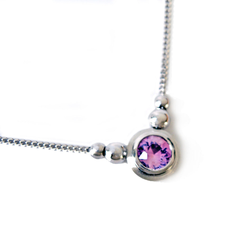 Pale Pink sapphire set in 18k white gold double bezel with 4 beads.