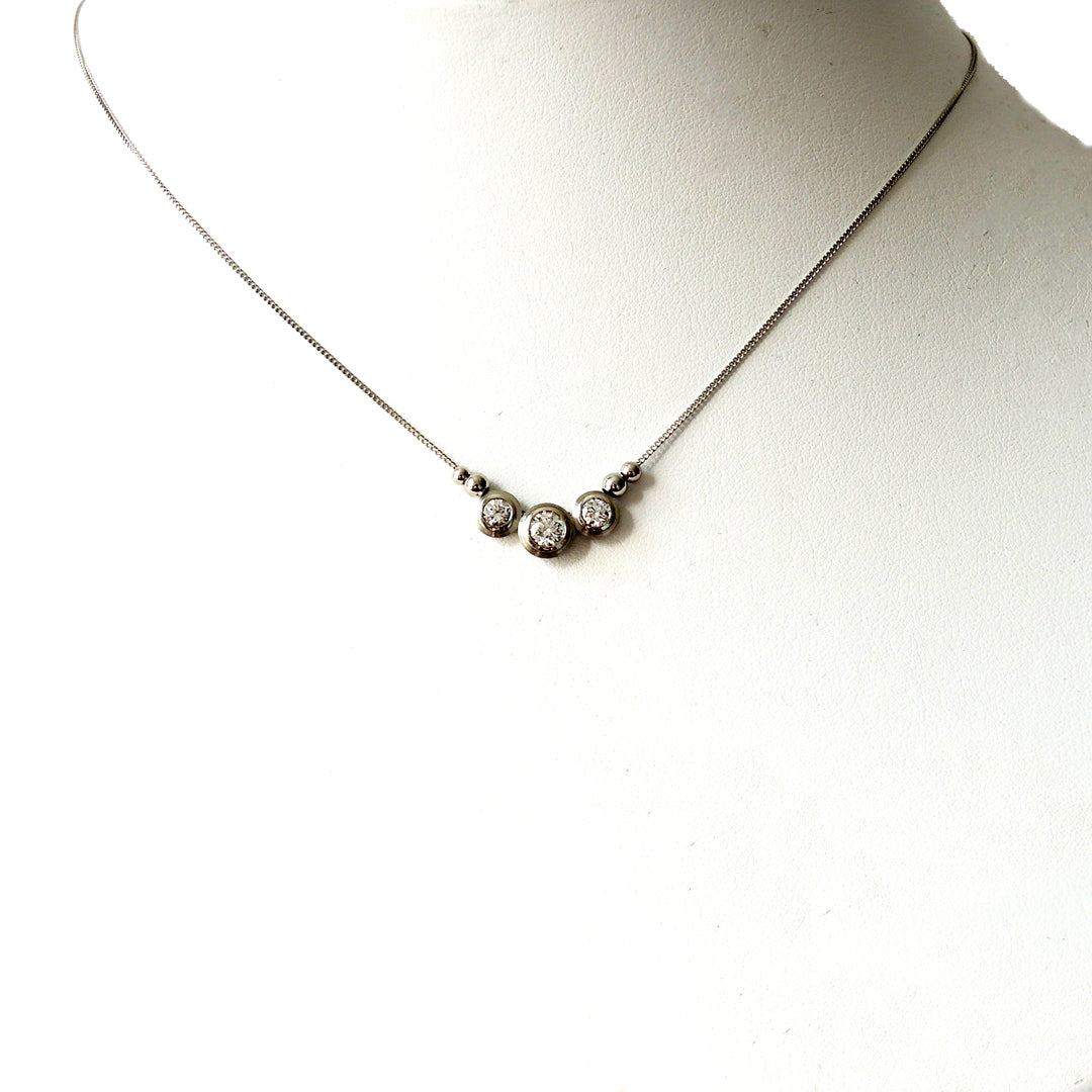 Series 8 - Simplicity | Bezel, Three Stone Pendant in Pt., .25 ct. and 2 x .12 carat diamonds on a prop neck