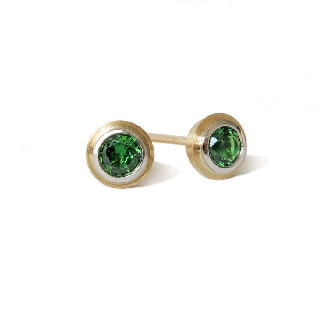 3 mm tsavorites set in platinum and 18k double bezels with a side view on one piece