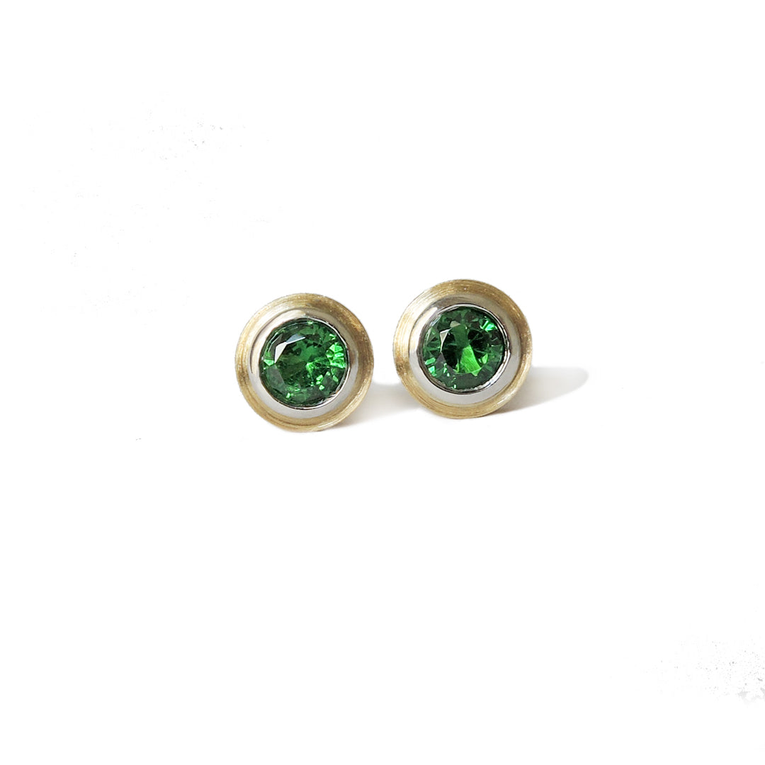 3 mm tsavorites set in platinum and 18k double bezels with a side view on one piece